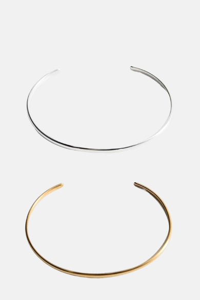 Gouden armband van MANGO, met een minimalistisch ontwerp en een open manchetstijl.