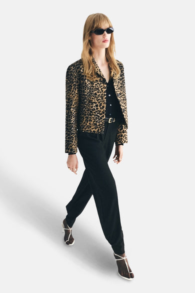 Bruine blazer van MANGO met dierenprint, gedragen met een zwart shirt en zwarte pantalon met riem.