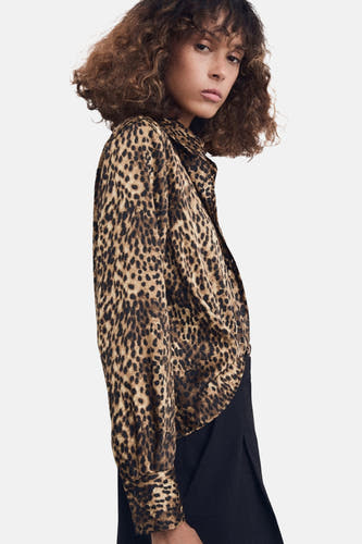 Veelkleurig, lang mouwen hemd van MANGO met luipaardprint en zwarte broek.