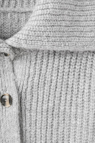Gilet gris de MANGO, avec une texture grossière et une fermeture à boutons bruns.