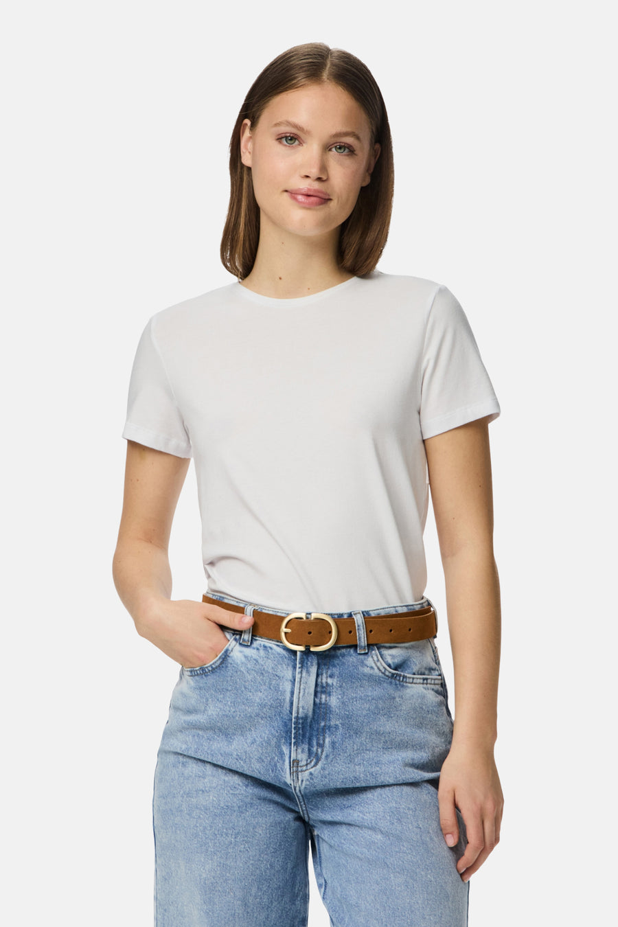 Ceinture brune de PIECES, avec une boucle ronde dorée et portée sur un jean bleu.