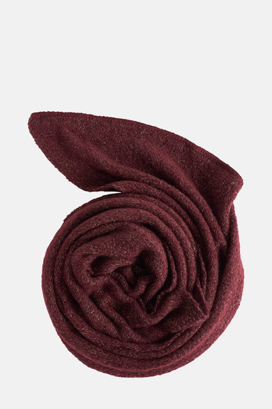 Écharpe de couleur bordeaux de Pieces, roulée, avec un fil scintillant tissé dans le tissu.