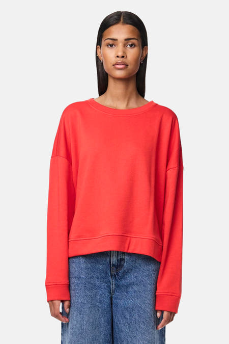 Rode sweater met ronde hals van PIECES®, gecombineerd met een blauwe jeans.
