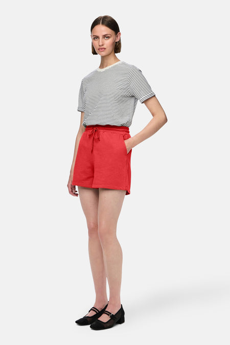 Short rouge de PIECES, associé à un T-shirt rayé et des chaussures noires.