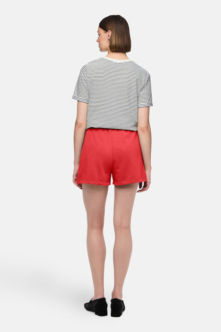 Short rouge de PIECES, associé à un t-shirt rayé et des chaussures noires, vu de dos.