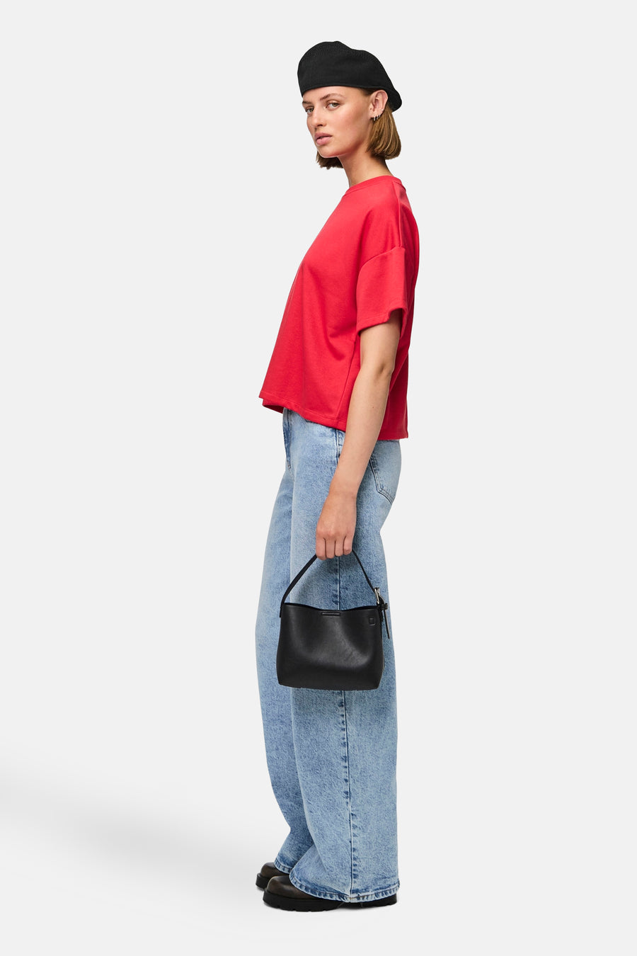 Rood T-shirt met korte mouwen van PIECES, met wijde jeans en een zwarte tas.