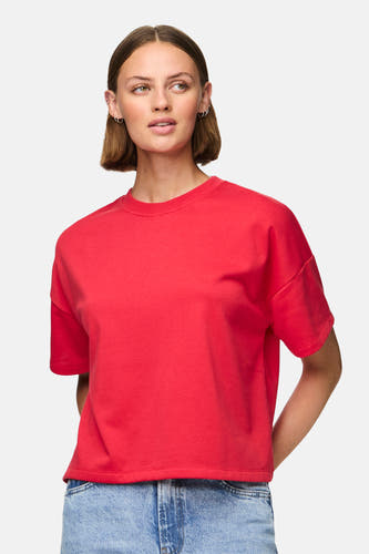 Rood T-shirt met korte mouwen van PIECES®, gedragen met een blauwe jeans.