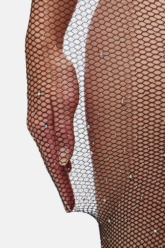Pantys noirs de PIECES, avec des paillettes décoratives et une structure filetée, sur un fond léger.