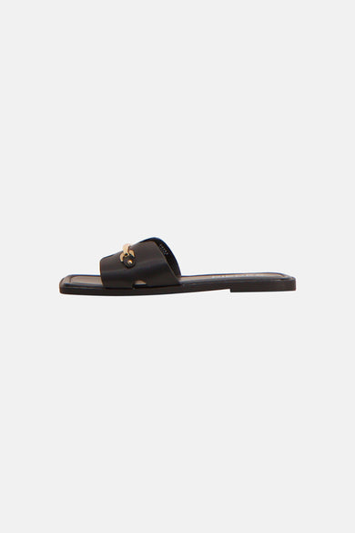 Zwarte slippers van PIECES® met brede band en goudkleurig kettingdetail, zijaanzicht.