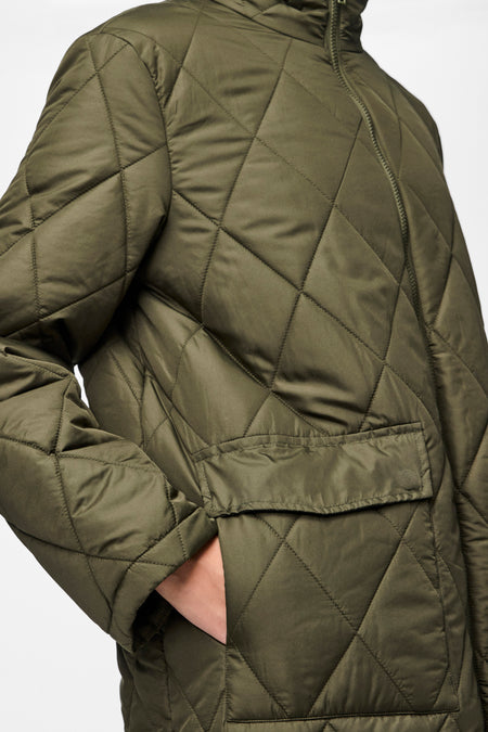 Groene jas van PIECES® met een ruitpatroon en steekzak, close-up.
