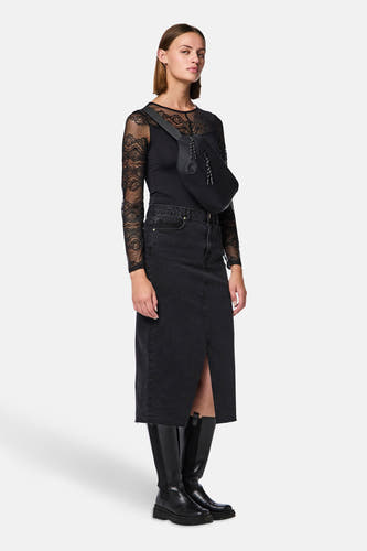 Corps noir de PIECES® avec des manches longues, combiné avec une jupe en denim noir et des bottes noires.