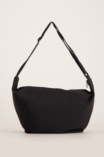 Sac à dos noir de Pieces, avec une s réable et un fermeture éclair sur le dessus.