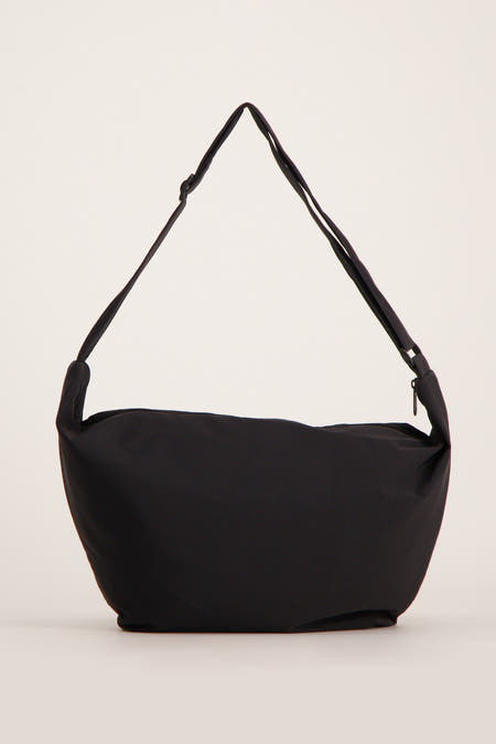 Zwarte schoudertas van Pieces, met een verstelbare band en ritssluiting bovenaan.
