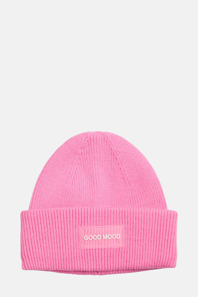 Roze muts van PIECES®, met geribbelde textuur en een opschrift "GOOD MOOD" op de omslag.
