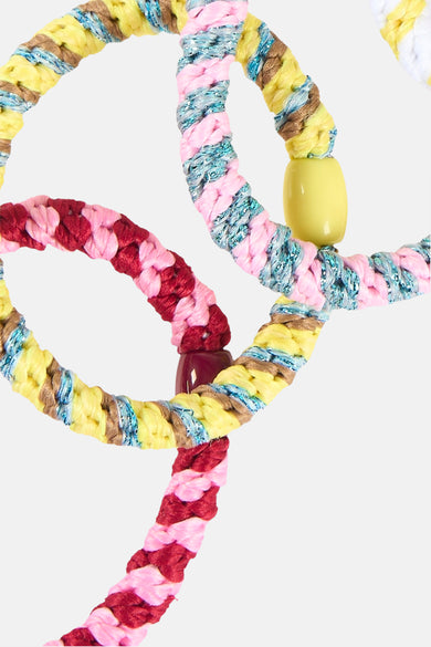 Multicolor gevlochten haar elastiekje van PIECES® met gele, roze, bordeauxrode en glimmende draden, versierd met kralen.