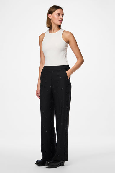 Zwarte broek van PIECES®, gedecoreerd met witte stippen en gecombineerd met een witte top.
