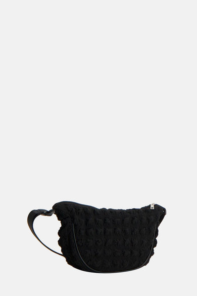 Sac à dos noir de PIECES® avec un motif texturé, fleuri et une courte sangle d'épaule.