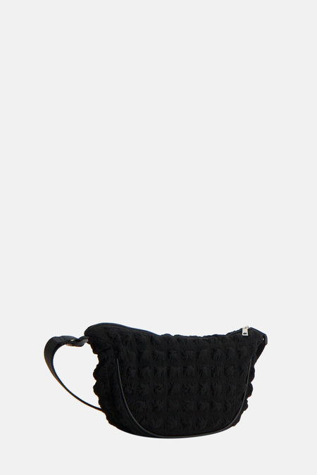 Sac à dos noir de PIECES® avec un motif texturé, fleuri et une courte sangle d'épaule.