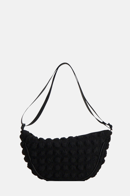 Sac à dos noir de PIECES®, avec une texture bosselée et une bandoulière lisse.