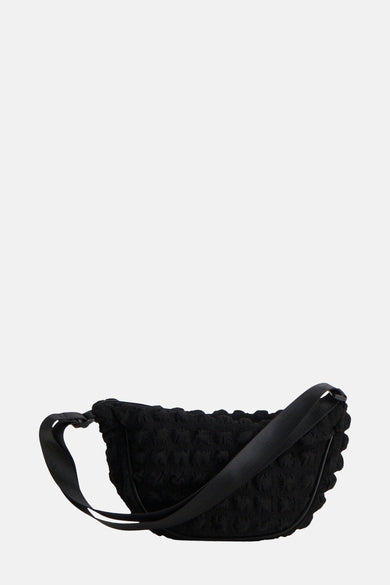 Sac à dos noir de PIECES® avec une texture tissée et une sangle d'épaule ajustable.