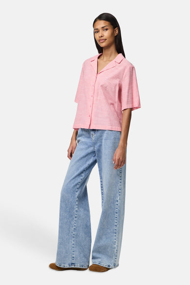 Roze overhemd met korte mouwen van PIECES®, met verticale strepen en gedragen met wijde jeans.
