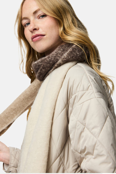 Écharpe d'hiver beige de Pieces, avec une texture douce et portée avec un pull en laine.