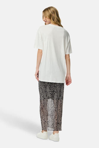 Wit T-shirt met korte mouwen van PIECES®, gedragen met een luipaardprint rok en witte sneakers, achteraanzicht.
