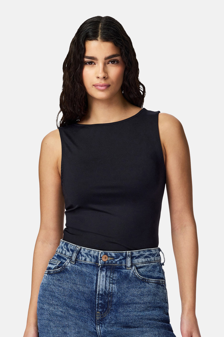 Body noir de PIECES®, avec un col rond et associé à un jean.