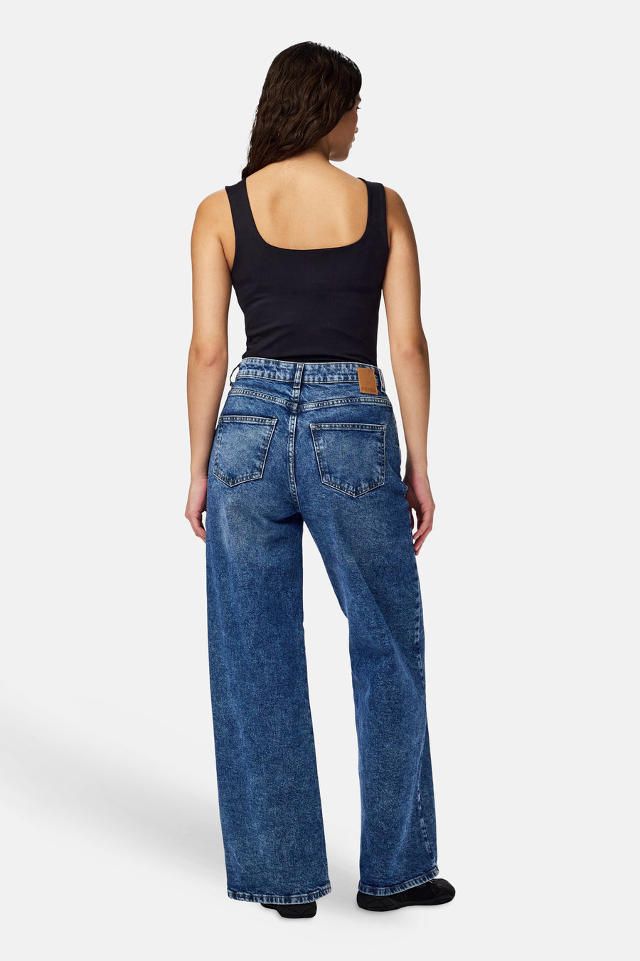 Body noir de PIECES® avec un décolleté carré, combiné avec un jean en denim bleu.