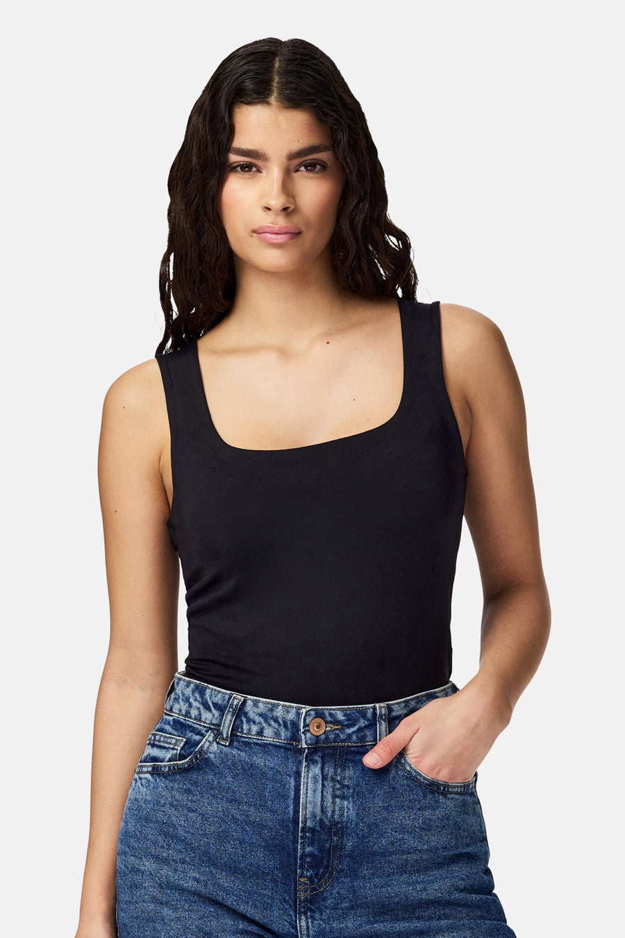 Body noir de PIECES®, avec encolure carrée et associé à un pantalon en jean.