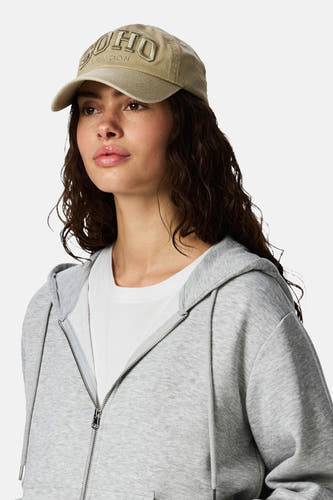 Gilet écru de PIECES, avec texte brodé et porté par une personne portant un sweat à capuche gris et un t-shirt blanc.