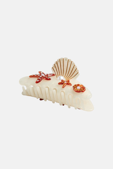 Pince à cheveux écru de PIECES® avec coquillage décoratif, étoiles de mer et détails floraux.