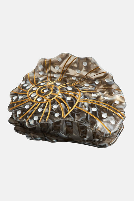 Pince à cheveux noire de PIECES® avec un design en spirale de couleur or et des pois blancs.
