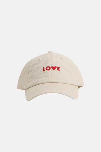 Witte pet van PIECES, met rode 'LOVE' borduring op de voorkant, op een egale achtergrond.

