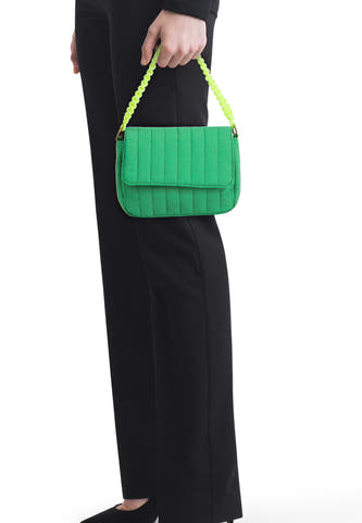 Groene schoudertas van PIECES® met verticale stiksels, een klep en een felgroene gevlochten handgreep.