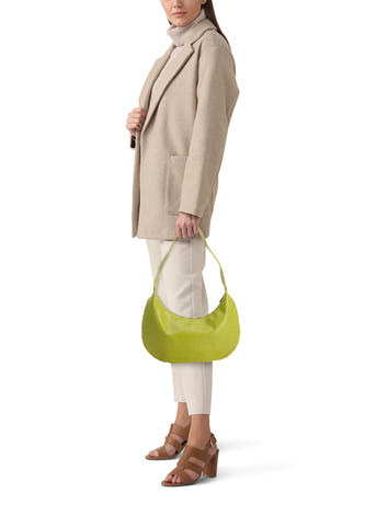 Sac à bandoulière vert brillant de PIECES® avec une forme souple et semi-circulaire, porté par un mannequin.
