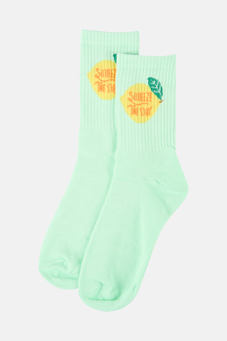 Groene sokken van PIECES® met een print van citroenen en de tekst "Squeeze the Day".
