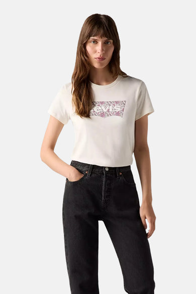 Ecru T-shirt met korte mouwen van Levi's, met een bloemrijk logo op de borst, gecombineerd met een zwarte jeans.
