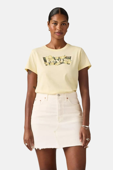 Geel T-shirt met korte mouwen van Levi's, met bloemenprint op de borst, gecombineerd met een witte rok.
