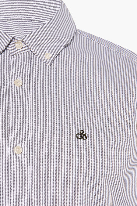 Chemise rayée à manches longues de SCOTCH & SODA, blanche avec fines rayures noires, boutons blancs et broderie sur la poitrine, gros plan vue de face