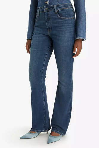 Donkerblauwe bootcut jeans van Levi's, gecombineerd met een jeans blouse en puntige hakken.
