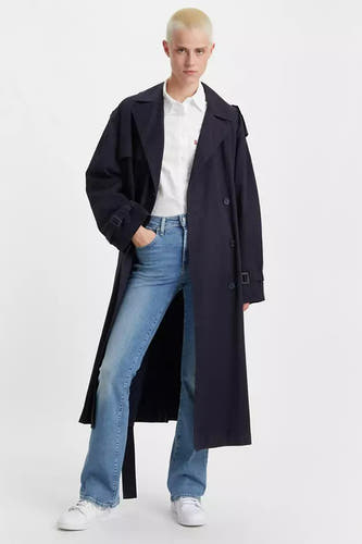 Jean en denim bleu clair bootcut de Levi's, associé à une chemise blanche et un manteau noir.