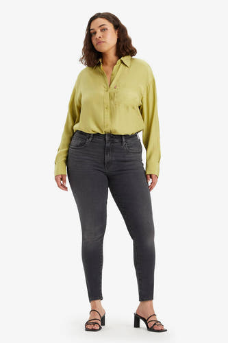 Donkergrijze skinny jeans van Levi's, gecombineerd met een gele blouse en zwarte hakken.
