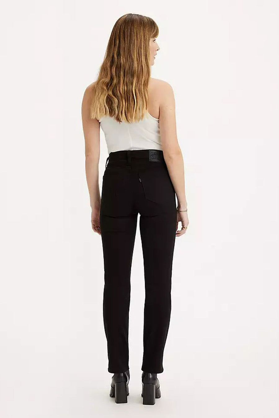 Zwarte straight jeans van Levi's, gezien vanaf de achterkant, gecombineerd met een wit hemdje en zwarte blokhak laarsjes.
