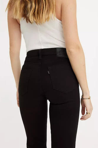 Zwarte straight jeans van Levi's, met achterzakken en leren patch, gedragen met een wit topje.
