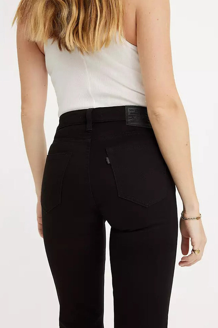 Zwarte straight jeans van Levi's, met achterzakken en leren patch, gedragen met een wit topje.
