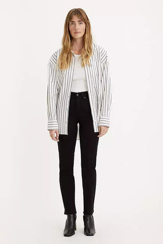 Zwarte straight jeans van Levi's, gecombineerd met een gestreept overhemd en zwarte enkellaarsjes.
