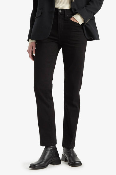 Zwarte straight jeans van Levi's, gecombineerd met een zwarte blazer en leren laarzen met blokhak.