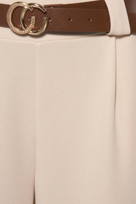 Beige pantalon met bruine riem en gouden gesp.