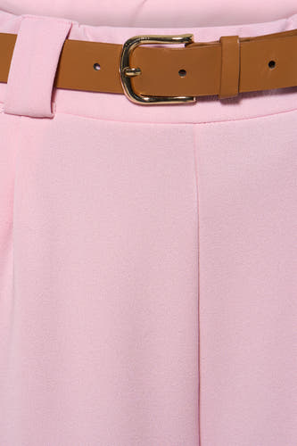 Pantalon rose de Terra di Siena, avec une ceinture marron à boucle dorée autour de la taille.